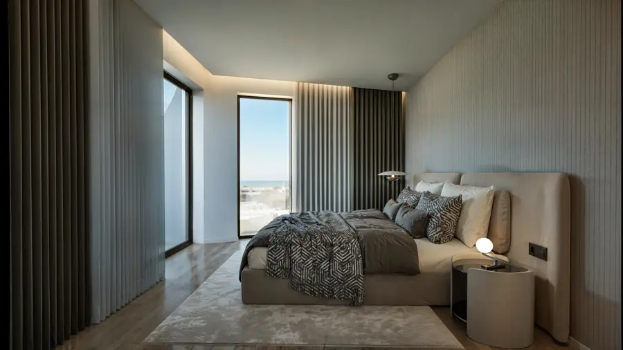 Suite com cabeceira estofada, iluminação suave e janela de grandes dimensões